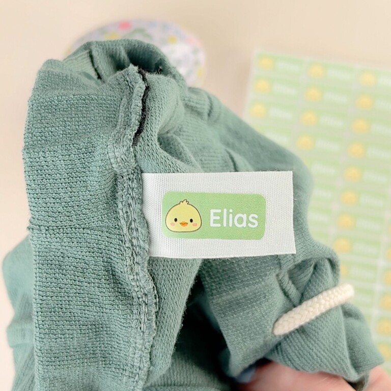 Namensaufkleber auf einem grünen Pullover