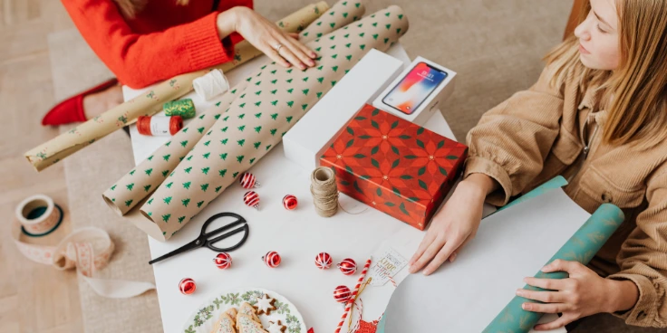 Weihnachtsgeschenke verpacken und beschriften – schön, praktisch, persönlich 4 Zwei personen bereiten geschenkpapier und deko fürs einpacken vor