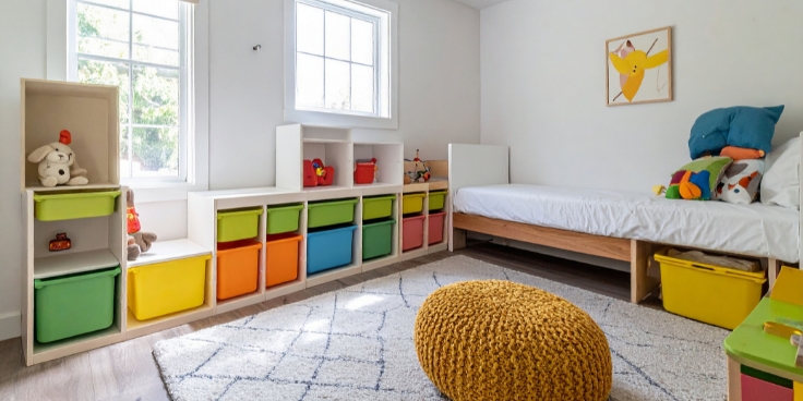 Aufgeräumtes kinderzimmer mit bunten aufbewahrungsboxen und bett