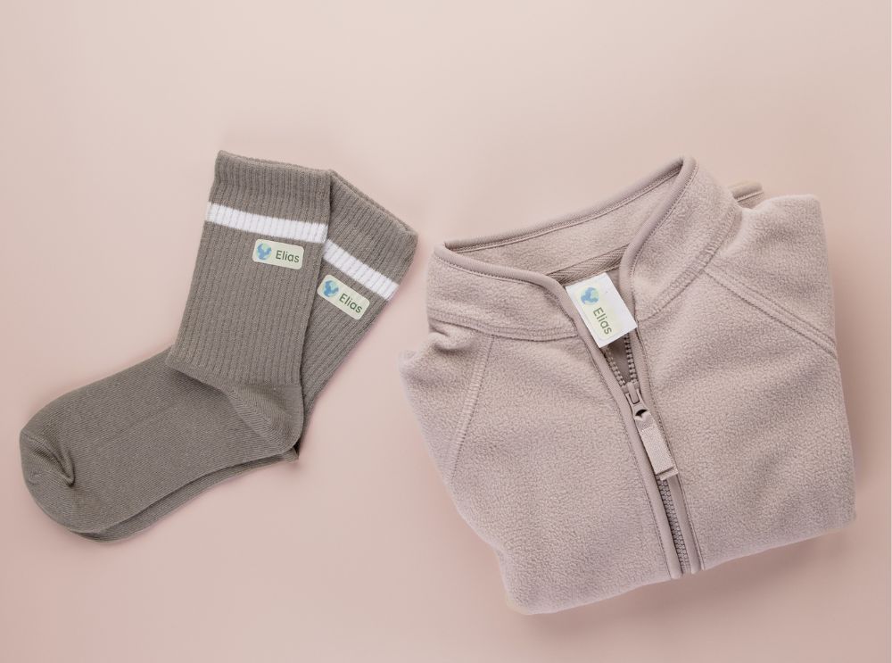 Bügeletiketten oder namensaufkleber für pflegeheime? Der vergleich 4 Gefaltete jacke und socken mit personalisierten namensaufklebern