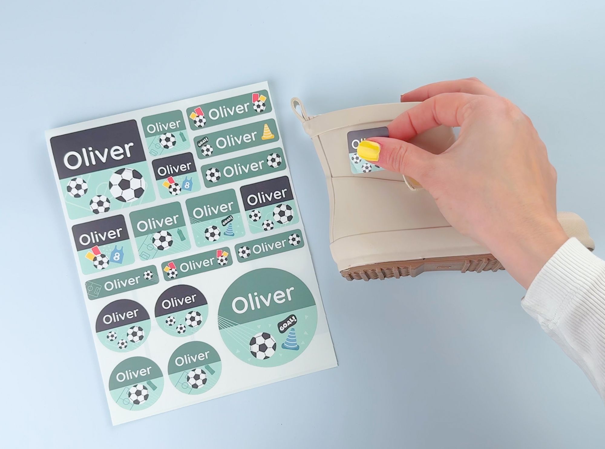 Welche größe ist die richtige für namensaufkleber? Tipps für deine wahl 7 Ein set mit großen namensaufklebern, daneben wird ein aufkleber auf einen kinderschuh geklebt