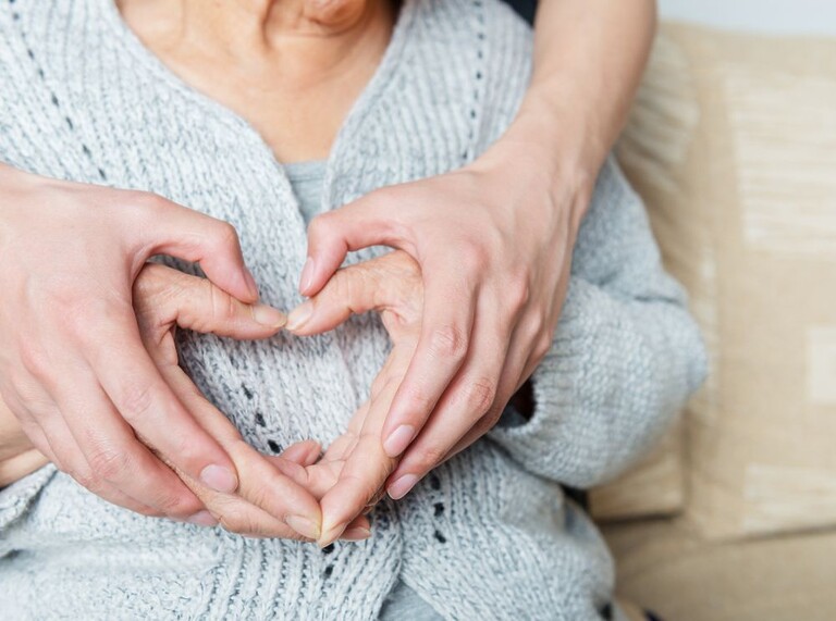Zwei Personen formen ein Herz mit ihren Händen
