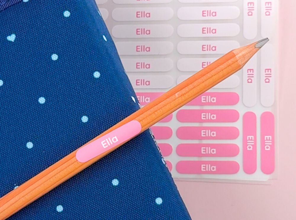 Namensaufkleber und bügeletiketten – personalisierte lösungen für jeden bedarf 5 Rosa stifte-aufkleber mit text "ella", der auf einen bleistift aufgeklebt ist.