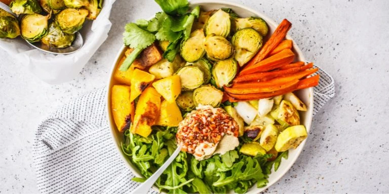 Gesund und organisiert durch den winter: tipps für familien 4 Ein buntes, gesundes wintergericht mit geröstetem gemüse, rosenkohl, kürbis, hummus und frischen kräutern