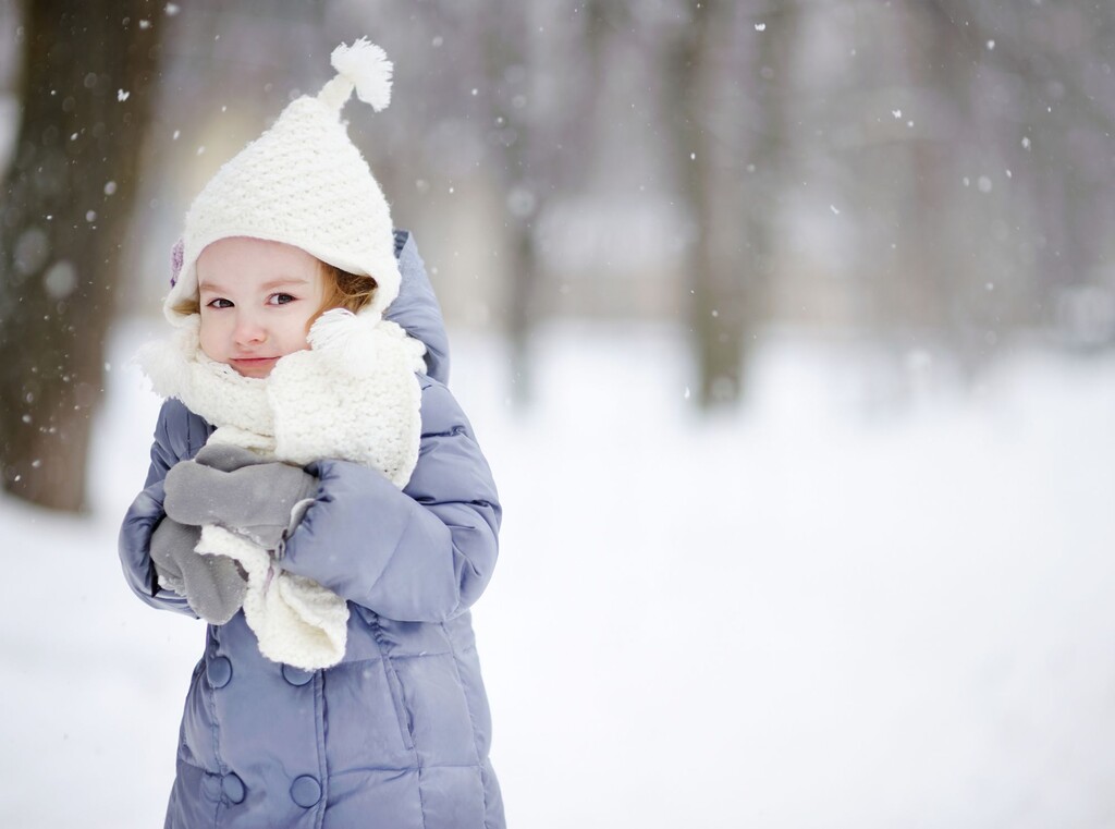 Fit durch die erkältungszeit: so stärkst du das immunsystem deiner kinder 1 Kind in dicker winterkleidung steht an einem verschneiten wintertag im schnee
