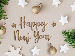 „Happy New Year"-Schriftzug in Gold, umgeben von weißen Sternen und festlichem Dekor