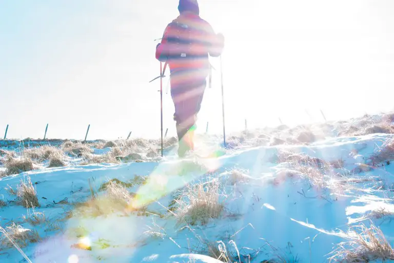 Kind mit Winterkleidung läuft im Schnee
