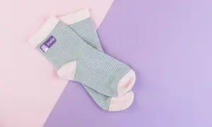 Grün geringelte Socken mit einem lila Bügeletikett.