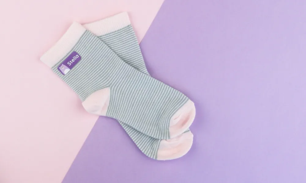 Grün geringelte Socken mit einem lila Bügeletikett.