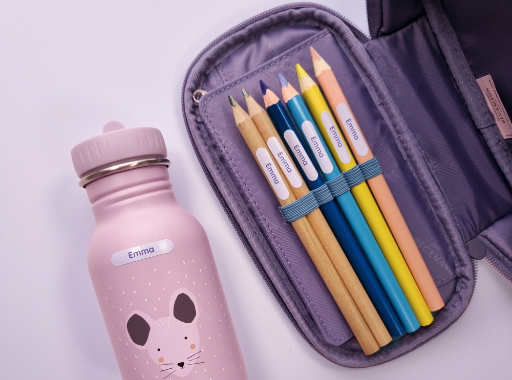 Schulranzen und schreibmaterial mit namensaufklebern beschriftet