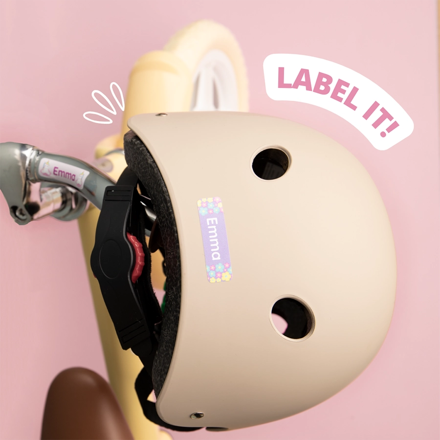 Beiger helm mit namensetikett 'emma' und blumenmotiv, neben einem rollerlenker.