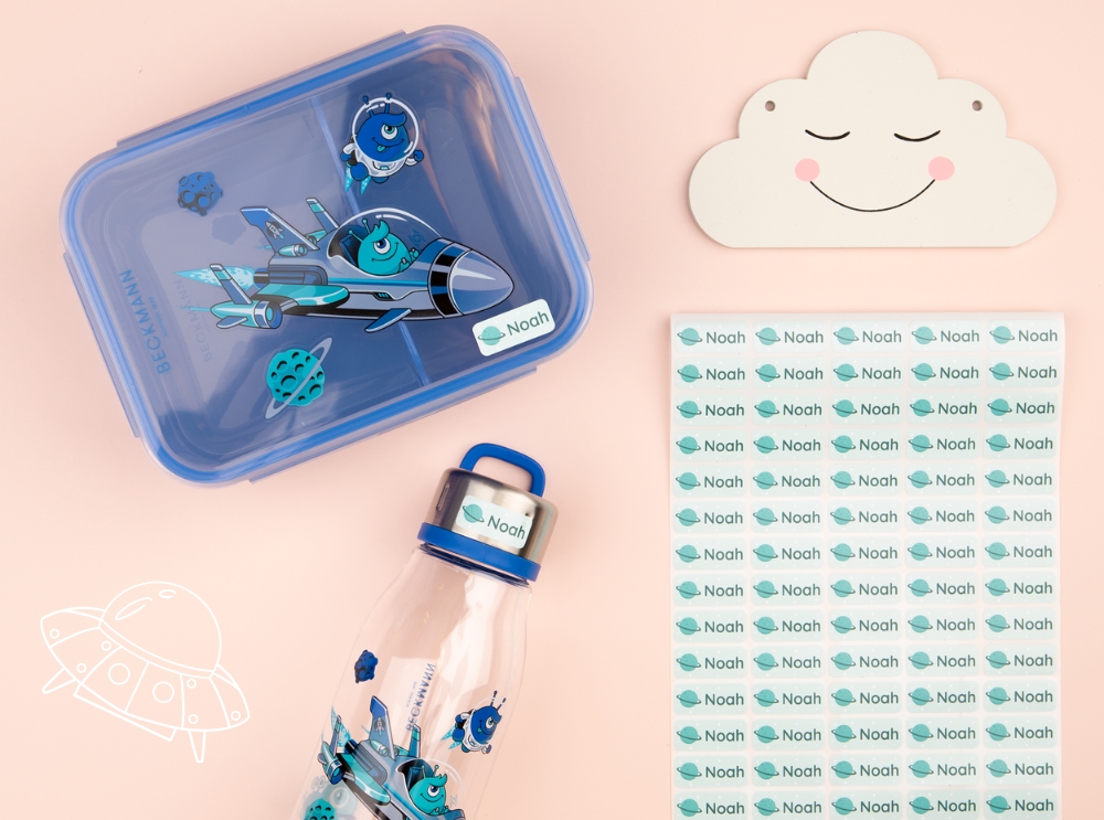 Blue lunchbox, water bottle, and name labels with a space-themed design.
