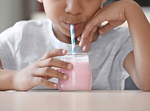 Kind trinkt Erdbeermilch