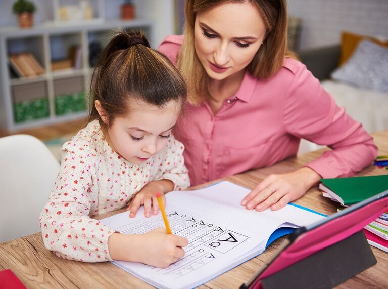 Mutter hilft Tochter bei den Hausaufgaben