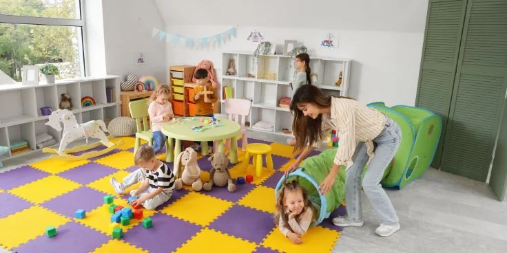 Kinder spielen mit tunnel und bauklötzen auf buntem teppich