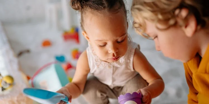 Kleinkinder spielen gemeinsam mit spielzeuggeschirr