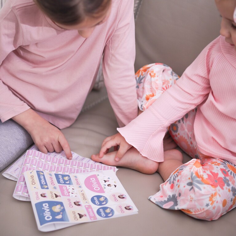 Kinder schauen sich große Namensaufkleber an