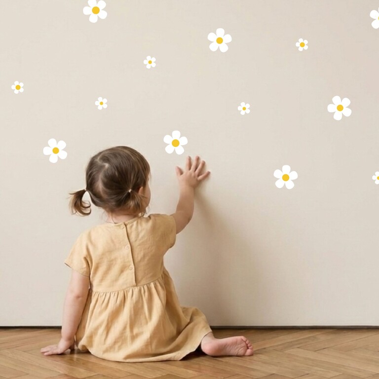 Kind klebt weiße Daisy Wandsticker an die Wand