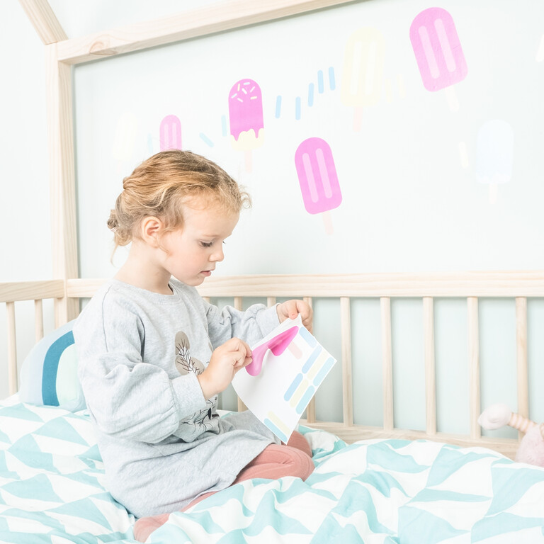 Mädchen klebt Eis am Stiel Wandsticker an die Wand