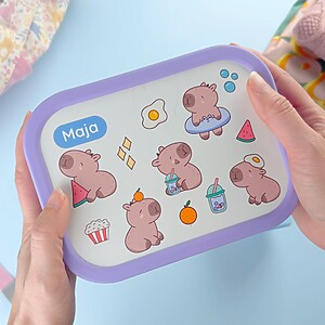 Lila Brotdose mit Namen und Capybara-Design