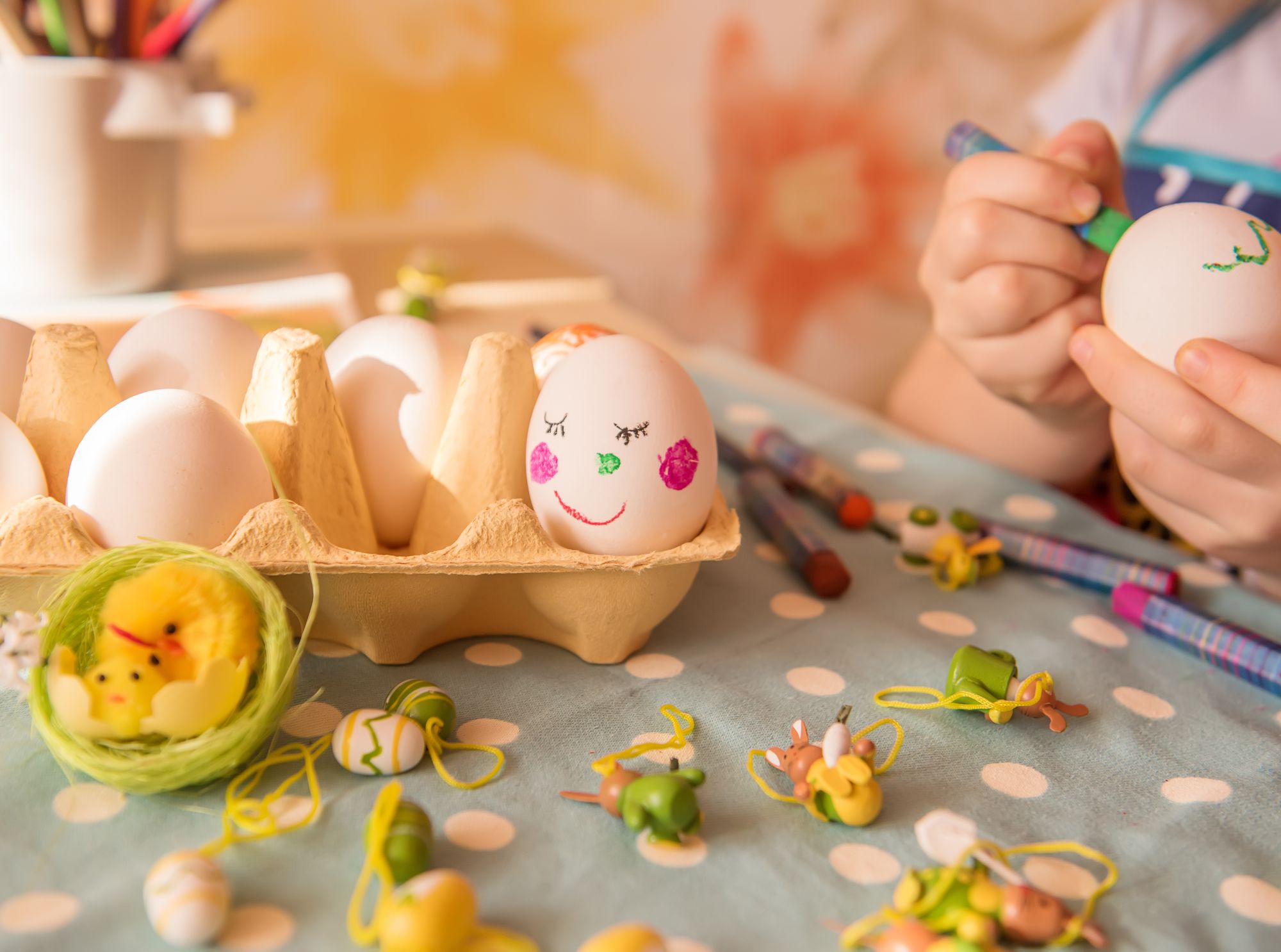 Osternest ideen: kreativ gestalten und sinnvoll befüllen 1 Ein kind bemalt eier in einem eierkarton